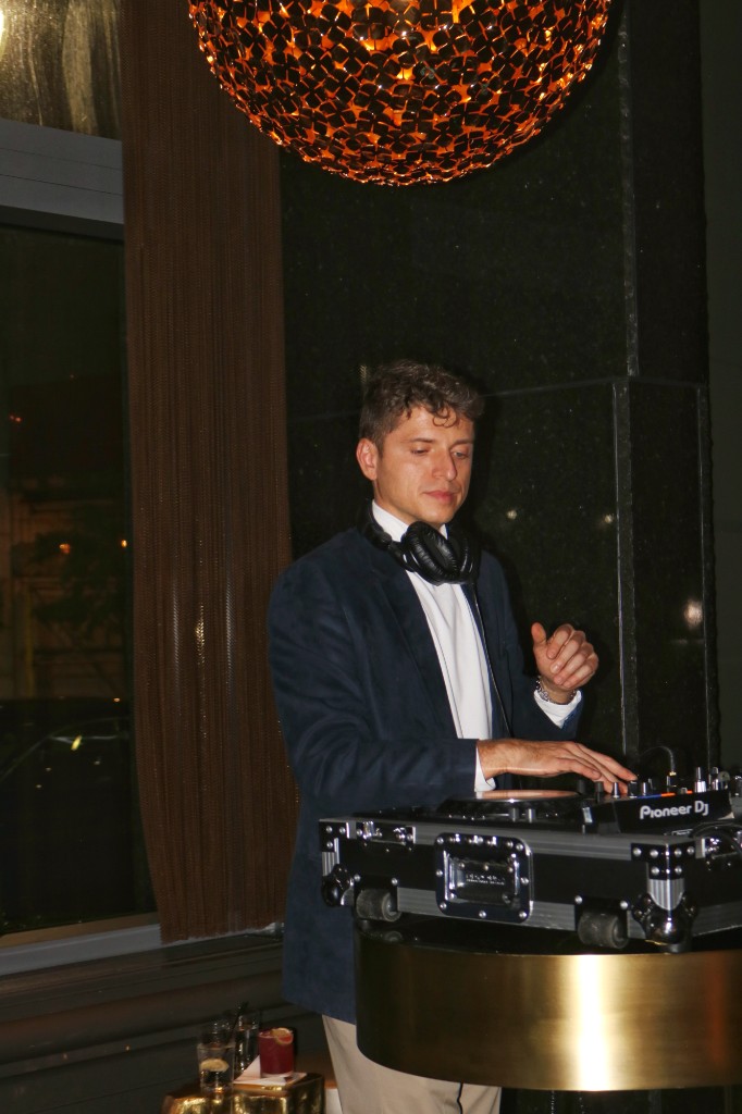 Adrian G DJing at W Lounge under a woven pendant light